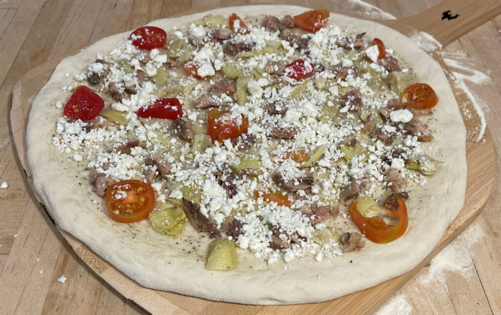 Final toppings on the sardine pizza