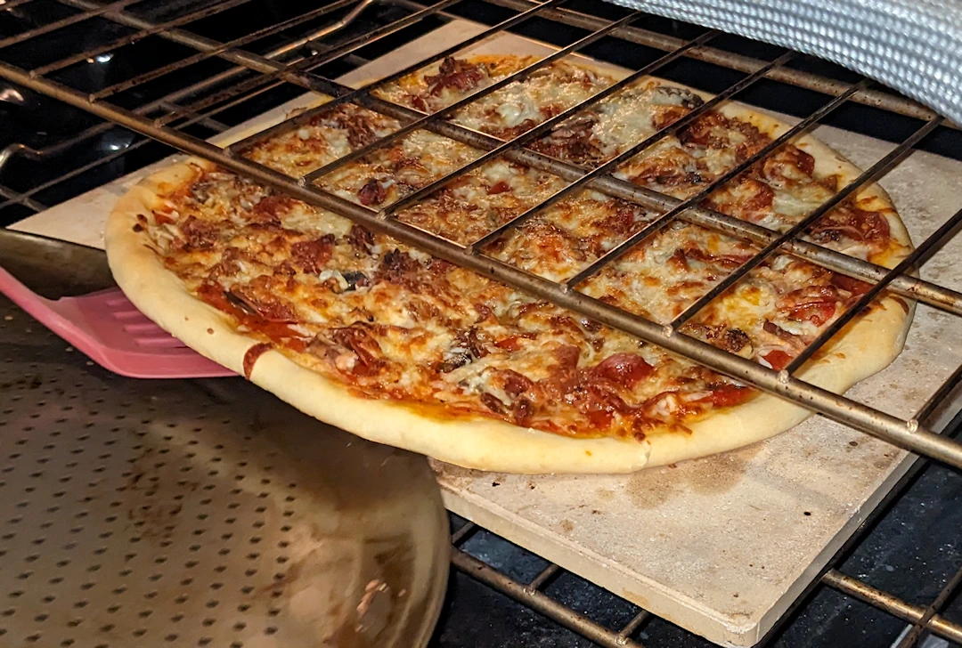 Launch that almost cooked pizza from the pan to the stone to finish the bottom!