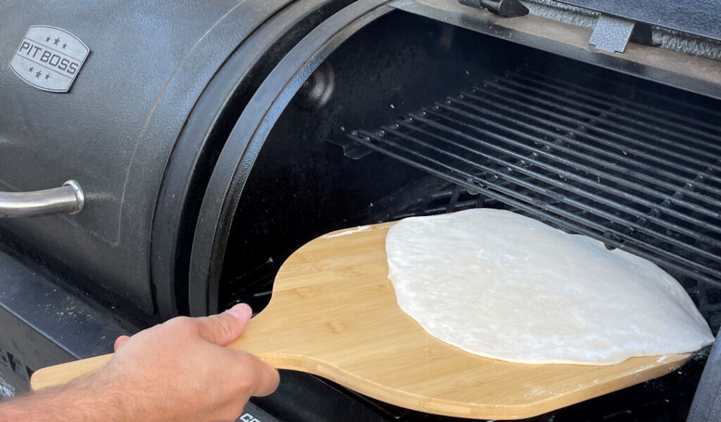 Launching pizza dough onto a grill
