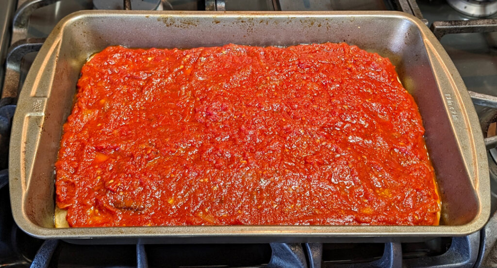Spread the sauce over the dough.