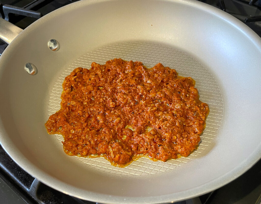 Cooking the raw chorizo in a skillet.