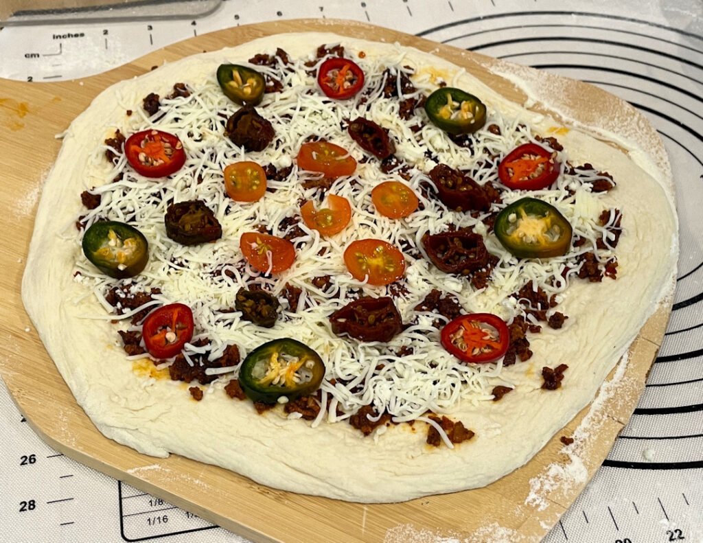 Pizza con chorizo topped and ready to cook.
