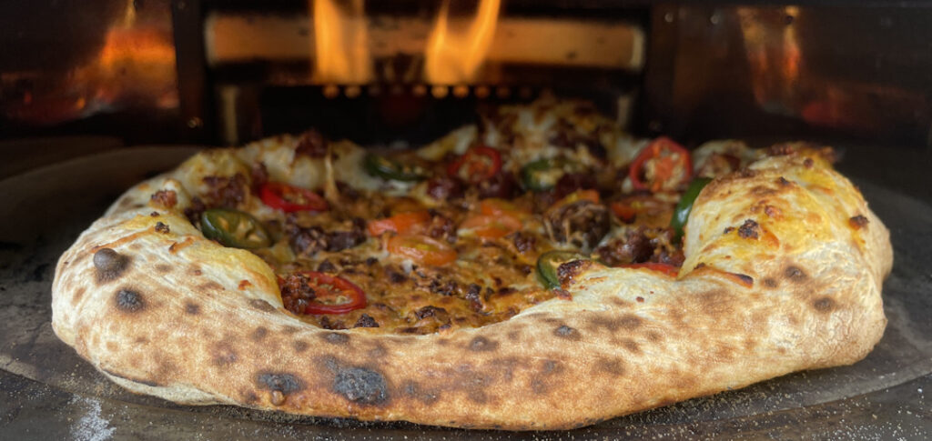 Pizza con chorizo in the pizza oven
