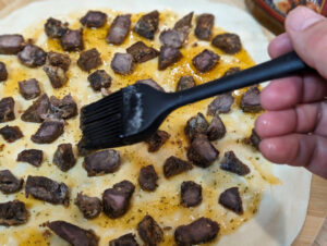 Baste the Spiedie meat in Spiedie sauce.