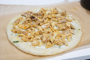 Top the Buffalo Chicken Pizza