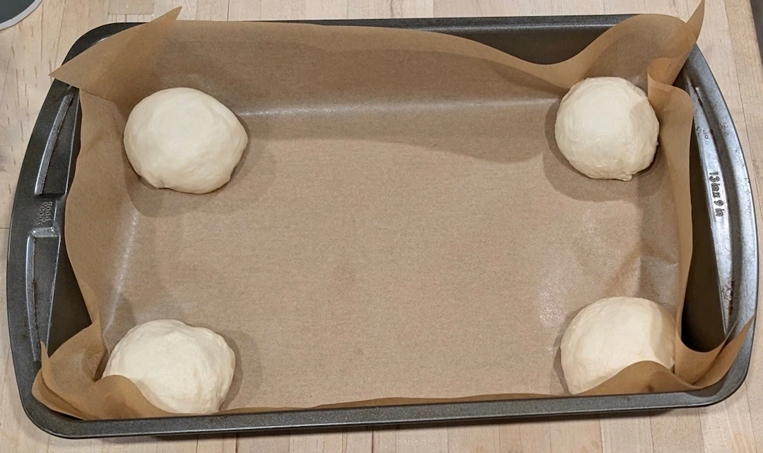 Hold the parchment paper down by first putting a roll in each corner.